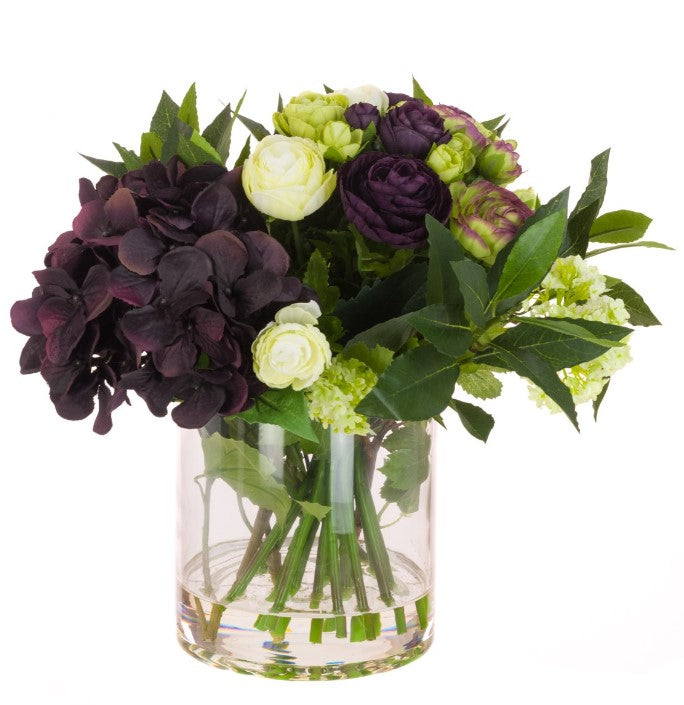 Faux flower arrangement with dark purple hydrangea and greenery foliage in vase